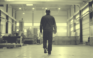 Factory worker walking, shot from behind.