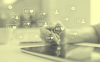 Speech bubbles with likes and comments coming out of a tablet.
