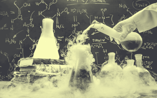 A lab experiment, closeup of test tubes, one of them is smoking.