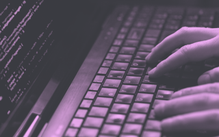 Person typing on a keyboard. Code on the screen.