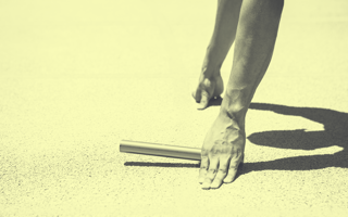 Shot of a person's hands holding a baton for the start of a relay race.