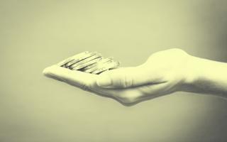 Outstretched hands holding gold coins.