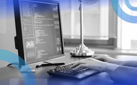 Python image of a programmers hands on a desktop keyboard and a monitor with code on it.