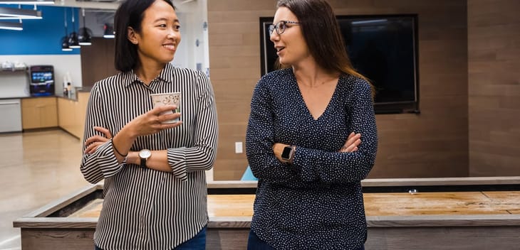 Two Alteryx team members chatting in the office