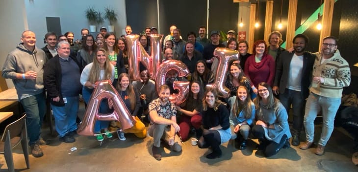 Angi group photo with team members holding ballons that spell ANGI