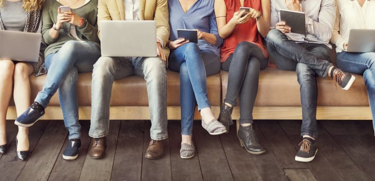 People consuming media on phones, tablets and laptops.
