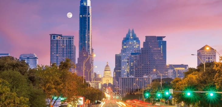 The Austin skyline photographed at dusk as the moon lingers in the horizon.