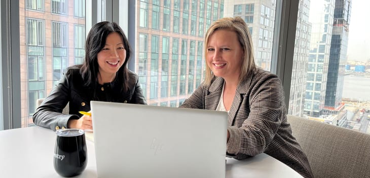 Yang Lu and Annette Hater work on a laptop together.