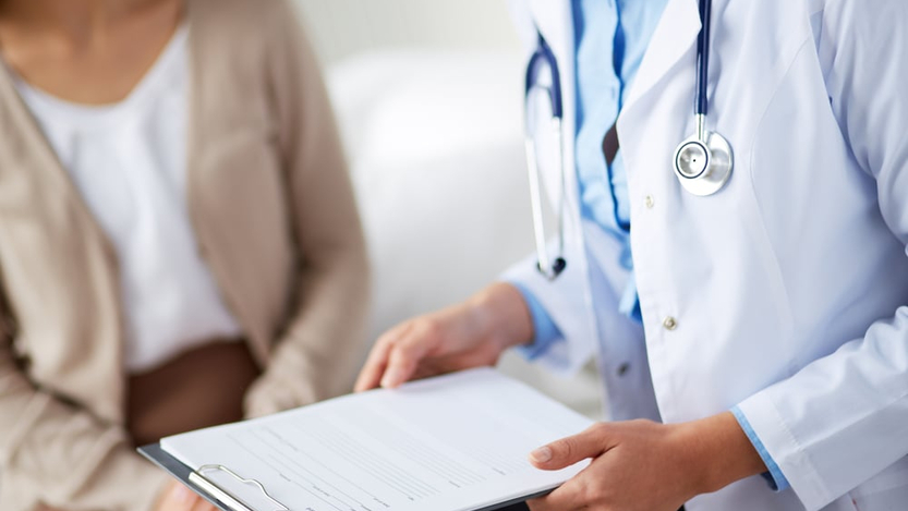 doctor with clipboard talking to patient