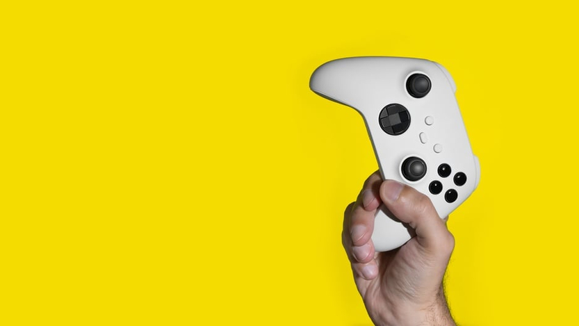 xbox controller in hand on yellow background xbox controller in hand on yellow background