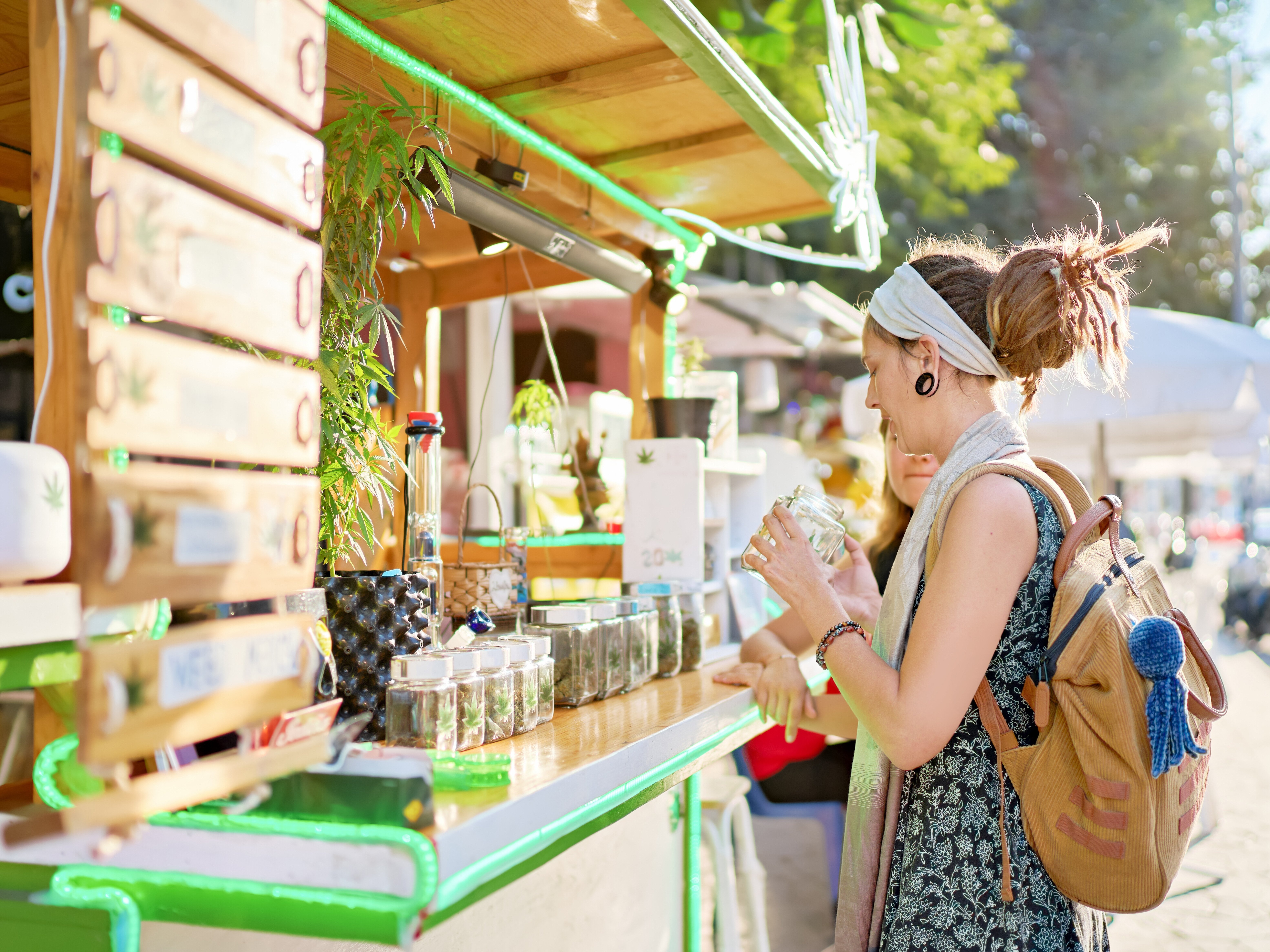Two women purchase cannabis at a cannabis retail cart