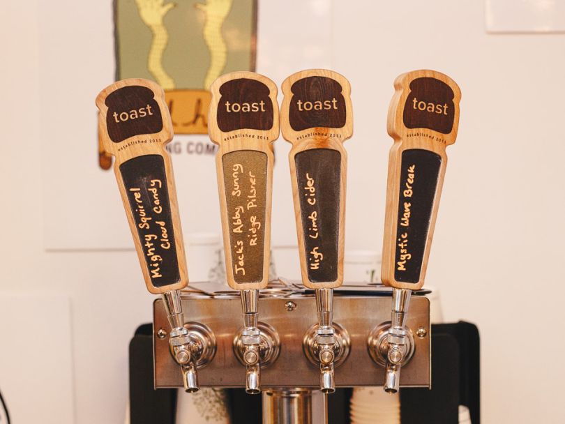Four beer taps with Toast's logo.