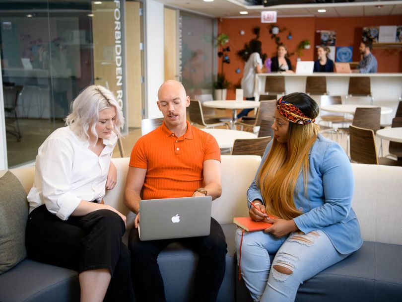 Signal staff sit on a sofa in Signal's large, open space