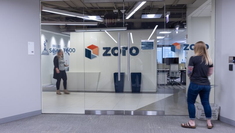 Two Zoro employees cross paths in the office.