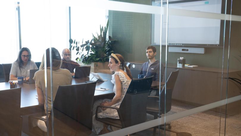Five DRW team members meet in a conference room.