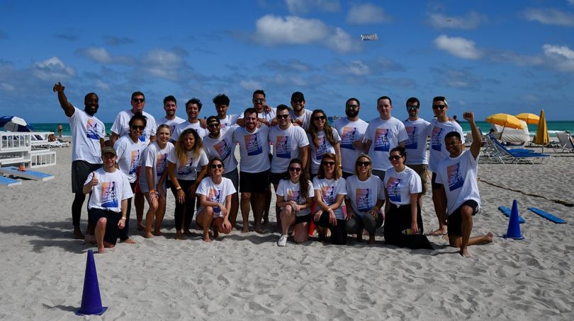 AB Tasty team members wearing matching shirts posing for a group photo at the beach