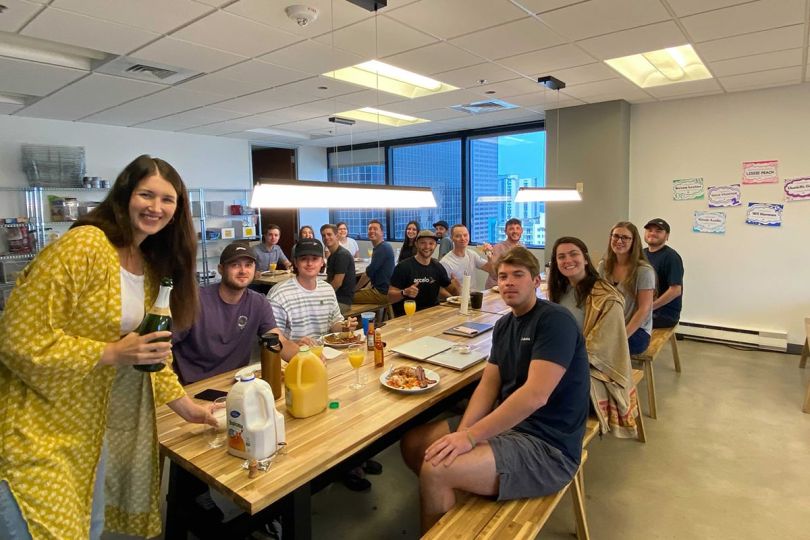 Accelo coworkers having a team breakfast together in the office
