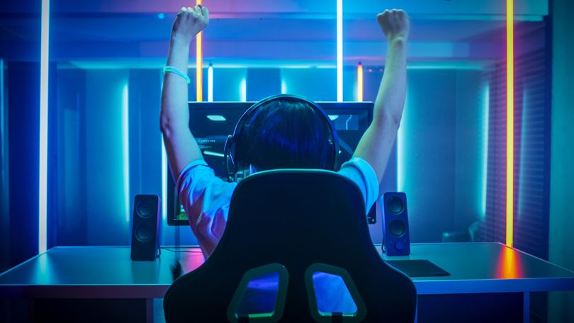 Gamer playing online video game at home on his personal computer
