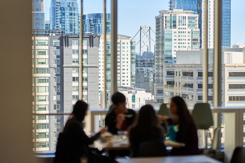 Benchling colleagues hav ing a meeting in the office with a city view out the window