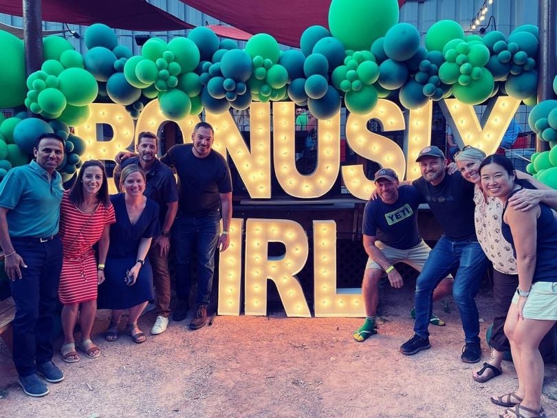 Bonusly team members with Bonusly IRL sign