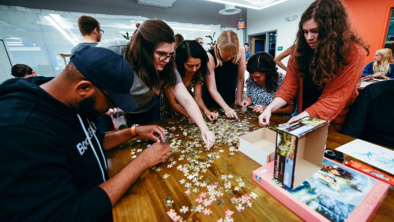 BookBub team members put together a puzzle together. 