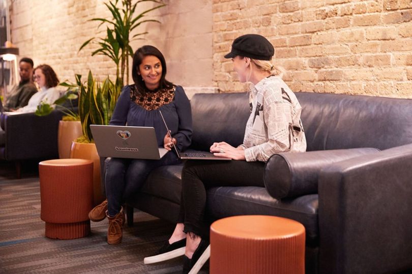 Two Bounteous team members sitting on a couch in the office having a 1 on 1