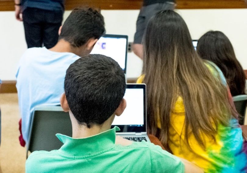 Students study skills in quantum computing on laptops inside a classroom.
