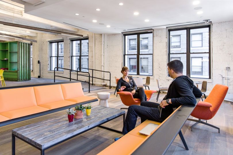 Employees having a conversation in the Capital One office.