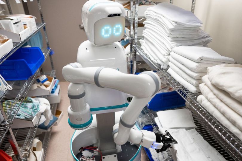Moxi is about human sized, with a gripper to hold things and eyes that indicate what direction it is heading.