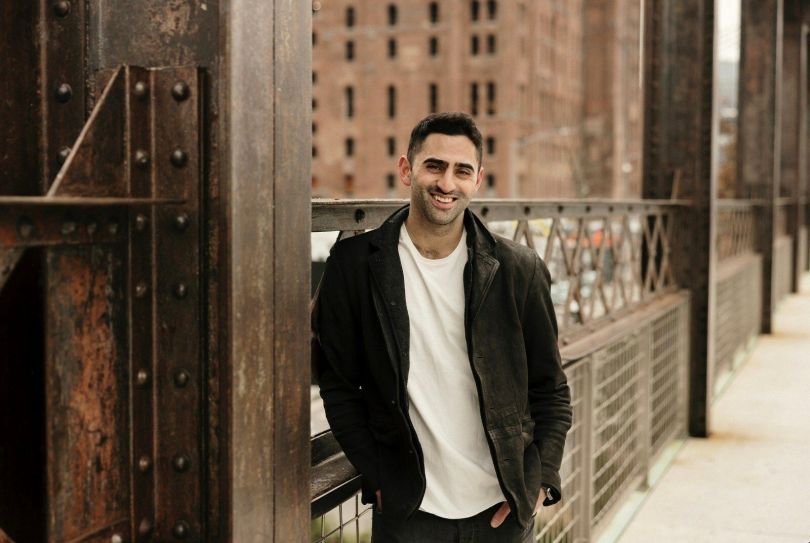 Omer Goldberg, Chaos Labs’ founder and CEO, stands outside along the railing of a bridge.