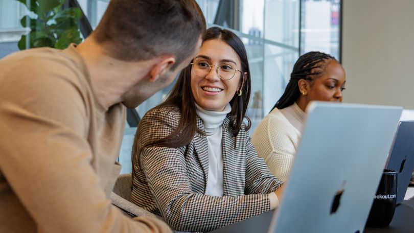 Checkout.com employees have a cheerful discussion. 