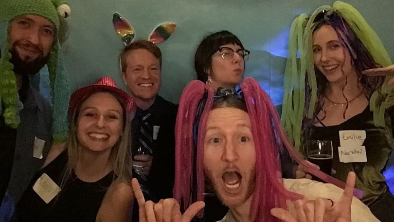 A group of six Clean Power Research employees post for a photo at a team all-hands meeting dressed up in costumes.&nbsp;