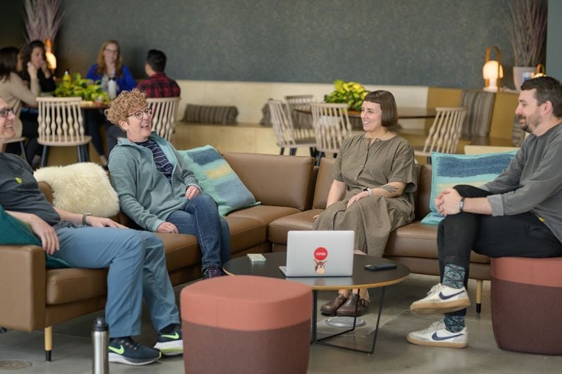 Conga team members sitting on couches in the office having a meeting