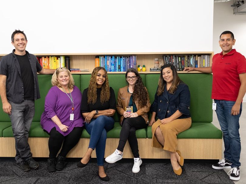 group photo of six Core Digital Media employees around a green couch