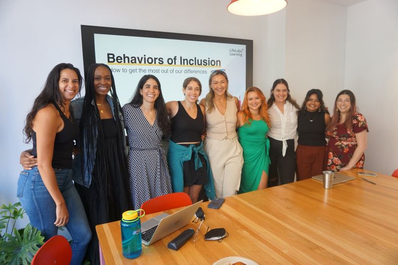 Group of women standing in a conference room posing for group photo