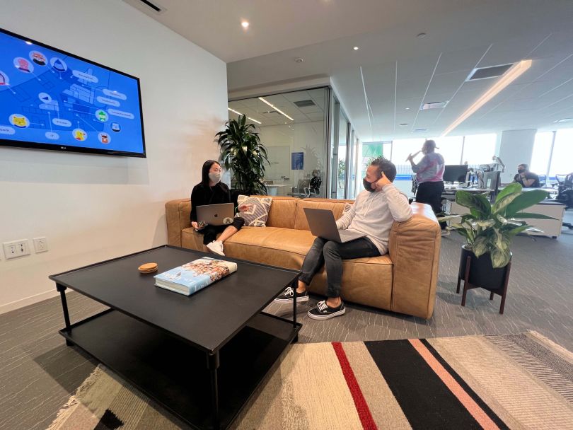 Dave teammates chatting while wearing masks in company office