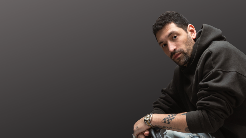 REALLY founder Adam Lyons poses for a photo against a dark grey background.