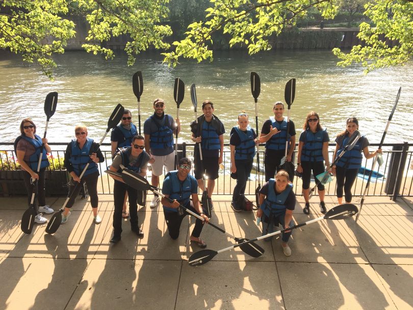 dina team on an outing holding oars