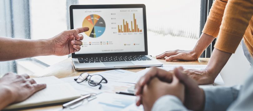 Business team looking at financial data on a laptop