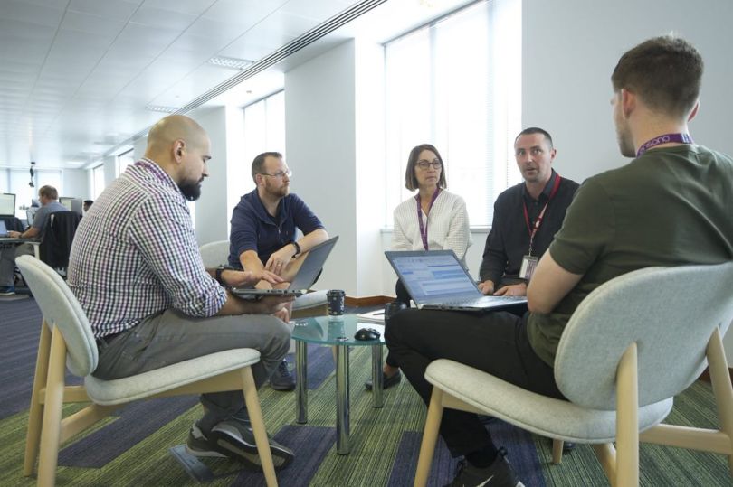 Ensono colleagues having a team huddle in the office