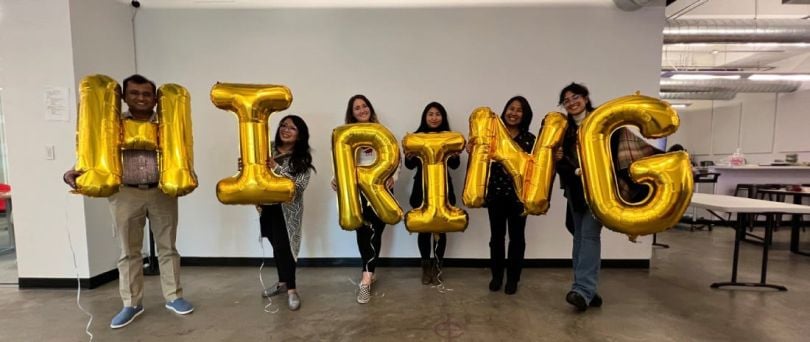 Firework team members holding balloons that spell hiring