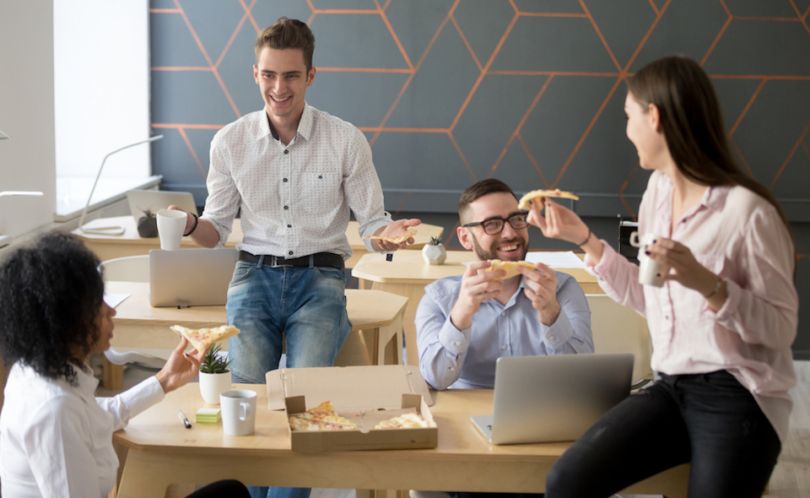 Staff members eating pizza