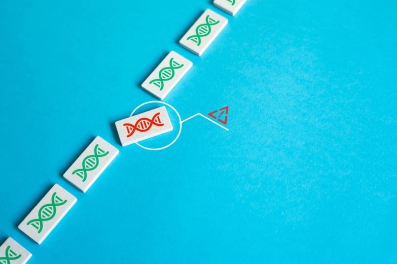 A line of dominoes with genetic symbols, highlighting a mutation.