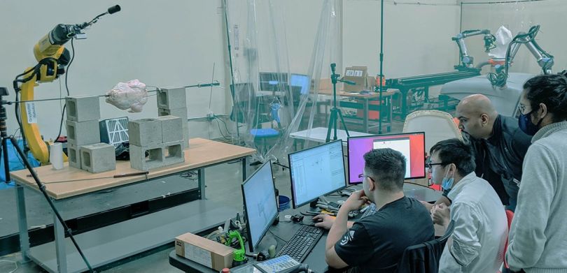 GrayMatter Robotics coworkers looking at a computer monitor in a testing facility