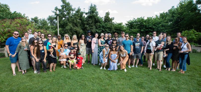 Group of people stand together on grass