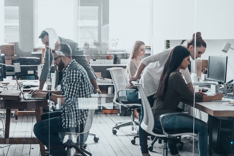 Group of young business people working and communicating together in creative office
