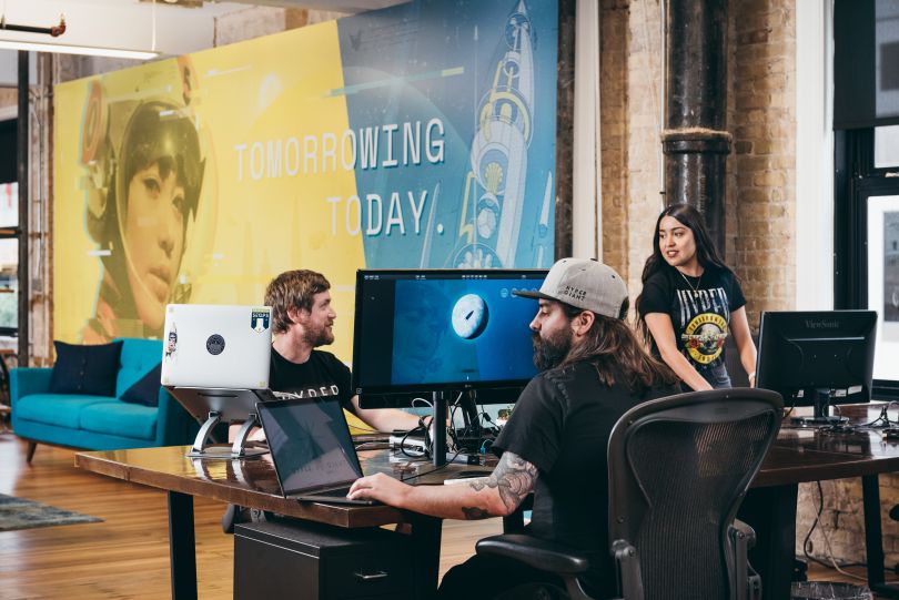 Members of the Hypergiant team work on computers.