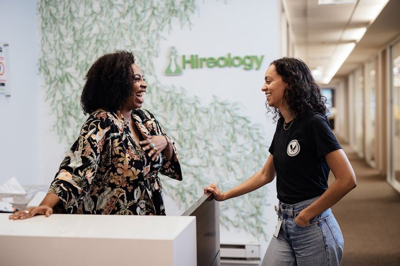Two Hireology team members smiling and chatting in the office