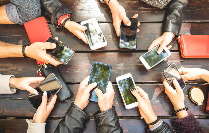 Detail of hands sharing content on social network with mobile smart phones