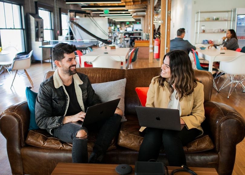 Two HopSkipDrive colleagues having a team huddle in the office